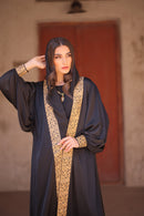 Woman wearing Dark Abaya with Gold trim 