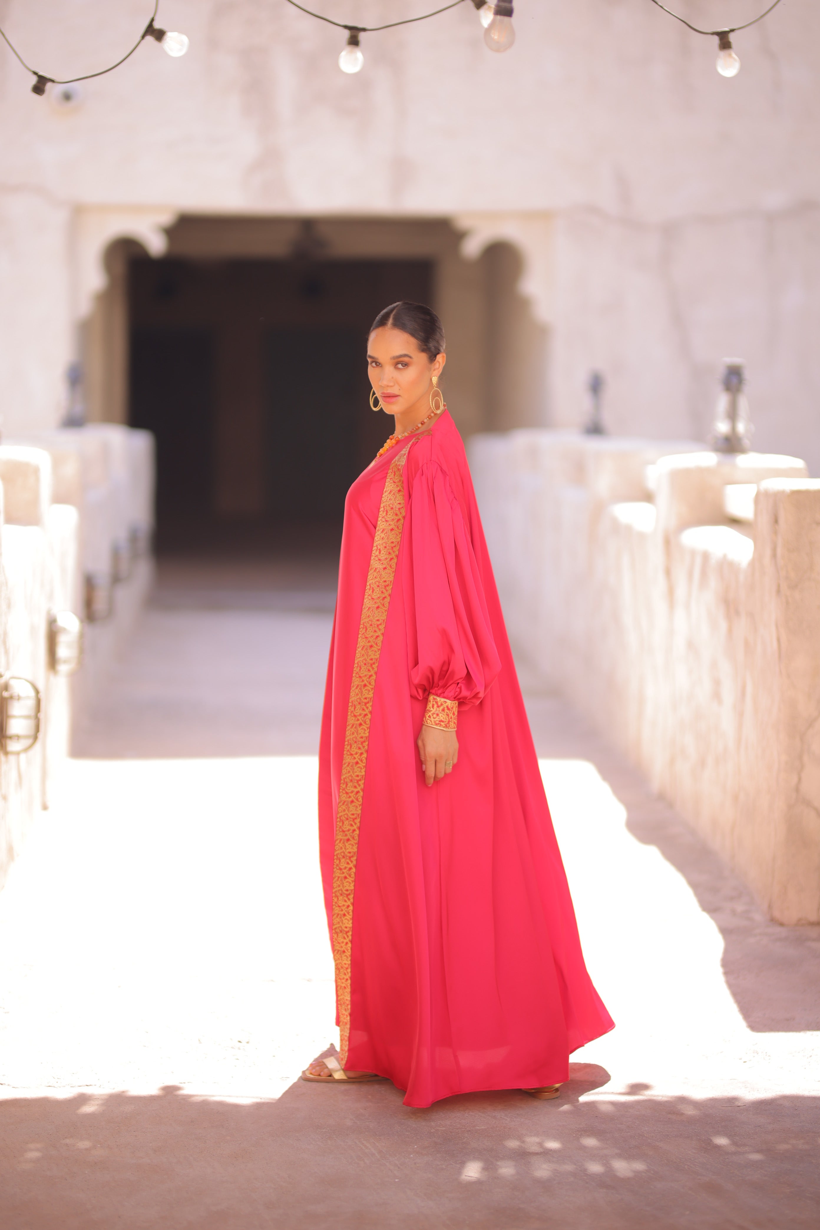 Woman in a Deep Pink Abaya standing outdoor 